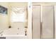 Bathroom with a soaking tub, shower, and sheer curtains over the window at 1103 Larkspur Dr, Locust Grove, GA 30248