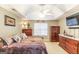 Spacious main bedroom with a ceiling fan, carpet, and dark wood furnishings at 1103 Larkspur Dr, Locust Grove, GA 30248