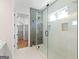 Glass shower is complemented by a custom-tiled wall, window, and built-in shelf with an adjacent closet at 1230 Hayes Sq, Peachtree City, GA 30269