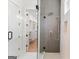 Modern glass shower is accented by a custom-tiled wall and silver fixtures, with closet access at 1230 Hayes Sq, Peachtree City, GA 30269