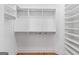 Walk-in closet with built-in shelving and rod storage for a neat and organized space at 1230 Hayes Sq, Peachtree City, GA 30269