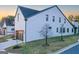 Beautiful home with white brick, dark roof, and manicured lawn with young trees at 1230 Hayes Sq, Peachtree City, GA 30269