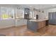 Bright, open kitchen featuring a large island, stainless steel appliances, and hardwood floors at 1230 Hayes Sq, Peachtree City, GA 30269