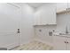 Convenient laundry room with white cabinets, sink, and modern fixtures at 1230 Hayes Sq, Peachtree City, GA 30269