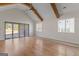 Bright living room features a vaulted ceiling, hardwood floors, ceiling fan, and glass patio doors at 1230 Hayes Sq, Peachtree City, GA 30269