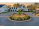 A street view features a circle with landscaping in front of white homes with three-car garages at 1230 Hayes Sq, Peachtree City, GA 30269