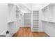 Walk-in closet is equipped with custom shelving, drawers and storage solutions with hardwood floors at 1230 Hayes Sq, Peachtree City, GA 30269