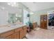 A full bathroom featuring double sinks, wooden cabinets, a large mirror, and ample storage space at 575 Chuli Rd, Locust Grove, GA 30248