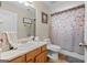 Bathroom with a sink, toilet, shower with floral shower curtain, and ample storage at 575 Chuli Rd, Locust Grove, GA 30248
