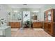 A full bathroom featuring double sinks, wooden cabinets, large mirrors, and tile flooring at 575 Chuli Rd, Locust Grove, GA 30248