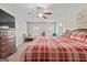 Bedroom with a large bed, carpet flooring, TV, and a ceiling fan for added comfort at 575 Chuli Rd, Locust Grove, GA 30248