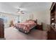 A cozy bedroom featuring carpet flooring, a ceiling fan, and two windows for ample natural light at 575 Chuli Rd, Locust Grove, GA 30248