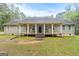 Charming ranch-style home featuring a welcoming front porch with columns and rocking chairs at 575 Chuli Rd, Locust Grove, GA 30248