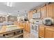 A well-equipped kitchen with wood cabinets, appliances, and a central island, open to a dining area and living space at 575 Chuli Rd, Locust Grove, GA 30248