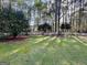 Scenic backyard with a lush lawn, mature trees, and a white picket fence at 116 Glendale Dr, Peachtree City, GA 30269