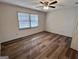 Bright bedroom with hardwood floors, ceiling fan, and a large window at 116 Glendale Dr, Peachtree City, GA 30269