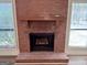 Close up of brick fireplace and hearth with windows to either side at 116 Glendale Dr, Peachtree City, GA 30269