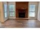 Brick fireplace with a wooden mantel and hearth and windows on both sides at 116 Glendale Dr, Peachtree City, GA 30269