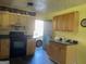 This kitchen has natural wood cabinetry, a black stove, and linoleum countertops at 266 Ridge Trl, Riverdale, GA 30274