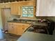 This cozy kitchen has natural wood cabinetry, a black stove, and linoleum countertops at 266 Ridge Trl, Riverdale, GA 30274