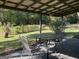 Covered patio featuring a glass table with chairs surrounded by well-maintained backyard greenery at 266 Ridge Trl, Riverdale, GA 30274