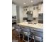 Well-appointed kitchen featuring a large island with seating and stainless steel appliances with white cabinets and backsplash at 813 Creekgarden Court, Atlanta, GA 30339