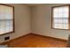 Sunlit bedroom featuring gleaming hardwood floors and two windows for natural light at 6099 Winview Dr, Forest Park, GA 30297
