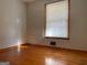 A cozy bedroom features hardwood floors and a window with blinds allowing soft light at 6099 Winview Dr, Forest Park, GA 30297