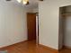 An empty bedroom featuring neutral-toned walls, wood floors, and an open closet space at 6099 Winview Dr, Forest Park, GA 30297