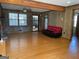 Open living room with hardwood floors, paneled walls, and a view of the front yard at 6099 Winview Dr, Forest Park, GA 30297