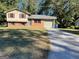 Split-level home with a brick facade, siding, attached garage and a spacious driveway on a sunny day at 6332 Valley Dale Dr, Riverdale, GA 30274