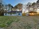 Single-story home nestled among mature trees, featuring a carport and shed at 117 Old Stagecoach Rd, Carrollton, GA 30116