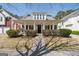 View of home exterior featuring a charming front porch, well-kept lawn, and tasteful landscaping at 4654 Liberty Square Dr, Acworth, GA 30101