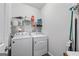 Functional laundry room with washer, dryer, shelving, and cleaning supplies for convenient chores at 4654 Liberty Square Dr, Acworth, GA 30101