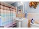 Charming bathroom with colorful accents, a pedestal sink, and a striped shower curtain for privacy at 275 S Bethany Rd, Mcdonough, GA 30252