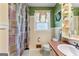 Cozy bathroom features a tiled floor, patterned shower curtain, and shelves with plants for a touch of nature at 275 S Bethany Rd, Mcdonough, GA 30252