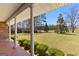 Expansive front yard view from covered porch featuring mature trees and manicured boxwoods at 275 S Bethany Rd, Mcdonough, GA 30252