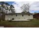 Rear view of brick home with a concrete patio and large trees in the backyard at 3065 Glendale Ct, Decatur, GA 30032