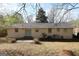 Rear exterior view showing the home's siding, sliding glass doors, and spacious backyard with mature trees at 767 San Miguel Dr, Stone Mountain, GA 30083