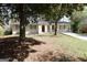 Inviting single-story home with a bright red front door, white brick facade, and mature trees in the front yard at 767 San Miguel Dr, Stone Mountain, GA 30083