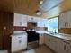 Updated kitchen with white cabinets, stainless steel appliances, and a view to the wooded yard at 1351 John Robert Dr, Morrow, GA 30260