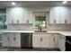 Bright kitchen featuring white cabinets, quartz countertops, stainless steel dishwasher, and a black faucet at 1351 John Robert Dr, Morrow, GA 30260