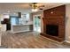 Spacious living room with brick fireplace, wood floors, and a view into the open kitchen at 1351 John Robert Dr, Morrow, GA 30260