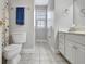 Neutral bathroom features a toilet, blue towel, window, and vanity with white cabinets at 315 Antebellum Way, Fayetteville, GA 30215