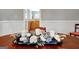 Close up of a dining table with decorative accents in front of a sunlit room and cabinets at 315 Antebellum Way, Fayetteville, GA 30215