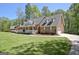 Brick home featuring a long front porch, a garage, and a well-manicured lawn at 315 Antebellum Way, Fayetteville, GA 30215