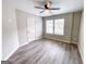 Bright bedroom featuring light gray paint, vinyl floors, and a ceiling fan and window at 102 Neal Ave, Stockbridge, GA 30281