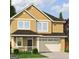 Charming two-story home with covered porch and two car garage and neutral colored siding at 102 Neal Ave, Stockbridge, GA 30281