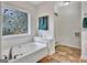Bright bathroom featuring a soaking tub, decorative window, and colorful tile floor at 676 Mcbride Rd, Fayetteville, GA 30215