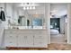 Bright bathroom vanity with white cabinets, a large mirror, and views into the main bedroom at 676 Mcbride Rd, Fayetteville, GA 30215